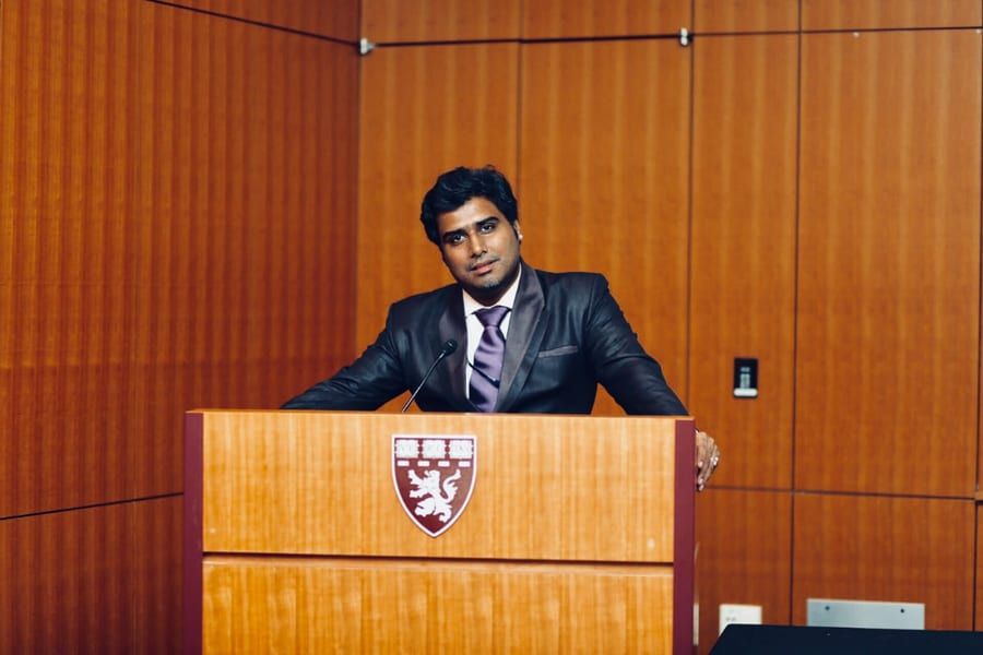 Dr Shahaji Shovakar speaking at a podium at Harvard Medical School